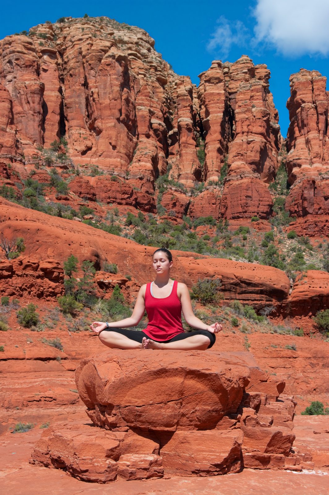 Person meditating on a red rock at a Sedona vortex site