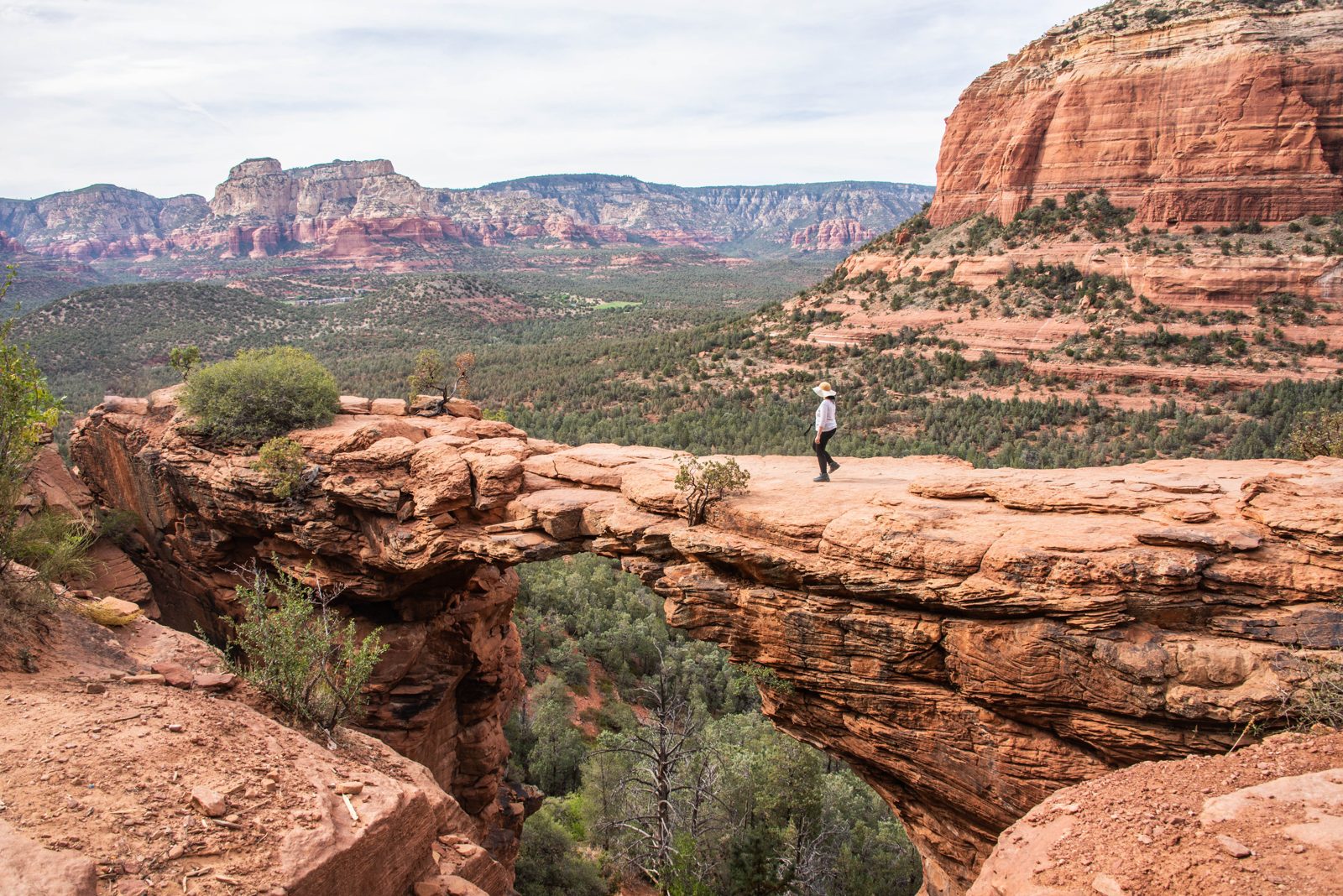 Hiker walking a red rock trail at sunrise in Sedona